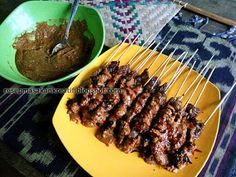 the skewers are being cooked on the yellow plate next to the green bowl