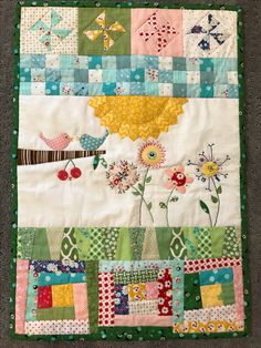 a patchwork quilt with flowers and birds on it