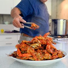 a man is cutting up some food on a plate in the kitchen with his fork