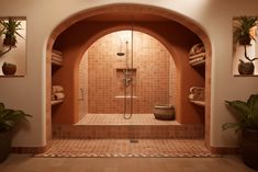 a bathroom with tiled walls and an archway leading to the shower area is pictured in this image