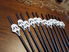 six black and white chopsticks sitting on top of a wooden table