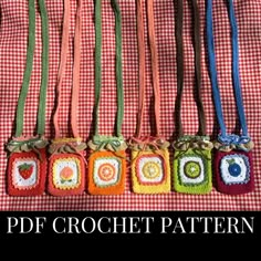 several crocheted purses are lined up on a red and white checkered tablecloth