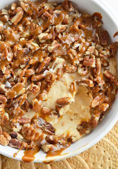 a bowl filled with bananas and pecans on top of a table next to crackers