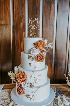 a three tiered wedding cake with orange flowers on the top and white frosting