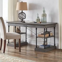 a desk with two chairs and a lamp next to it on a hard wood floor