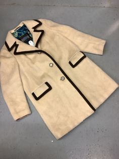 "Classic cut wool, button down LODENFREY jacket made in Austria. Beautiful beige coat with three coin buttons. Two large front pockets with ribbed flap details. Lovely blue floral lining and detailed material inside cuffs also. can be seen in photos. Small mark on right pocket that would likely come out with a dry clean. Otherwise in perfect vintage condition with very little wear. Measurements are as follows... SHOULDER TO SHOULDER 17\" COLLAR TO SHOULDER 6\" SLEEVE LENGTH 24\" PIT TO HEM 25\" Cream Wool Coat With Button Closure, Cream Wool Outerwear With Lapel Collar, Vintage Single Breasted Long Coat, Vintage Single-breasted Long Coat, Cream Wool Coat With Button Closure For Fall, Cream Notch Lapel Outerwear For Winter, Vintage Long Single-breasted Coat, Cream Wool Outerwear With Pockets, Spring Wool Coat With Buttons