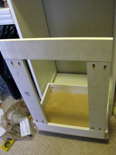 an unfinished cabinet is shown with the bottom section missing from it's door open