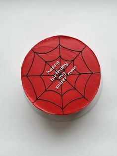 a red cake with a spider web design on it