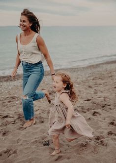 a mother and daughter playing on the beach