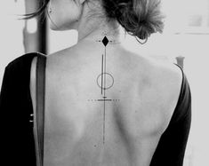 the back of a woman's neck with a geometric tattoo on it, and an arrow