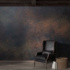 a black chair sitting in front of a wall covered in rusted metal foiling