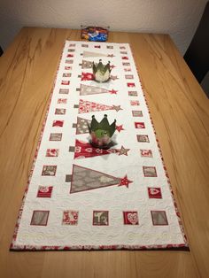 the table runner is decorated with red and white quilts, which have crowns on them