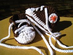 a crocheted hat and booties sitting on top of a yellow cushioned surface