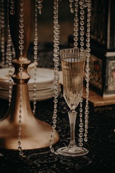 two champagne flutes sitting on top of a table next to plates and silver wares