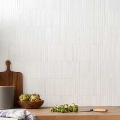 a kitchen counter with a cutting board, knife and bowl on it next to a wall