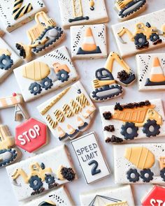 decorated cookies with construction theme are displayed on a white tablecloth, including trucks and road signs