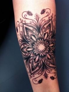 a woman's leg with an intricate tattoo design on the side of her leg