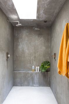 a bathroom with concrete walls and white flooring