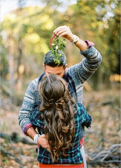 a man and woman are standing in the woods