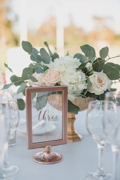 an elegant centerpiece with white flowers and greenery