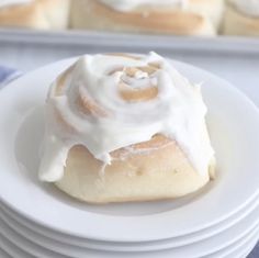 a white plate topped with rolls covered in frosting on top of eachother