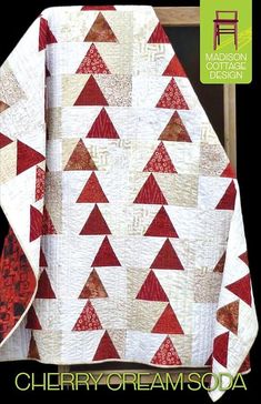 a red and white quilt with triangles on it