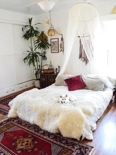 a bedroom with a white bed and rugs on the floor