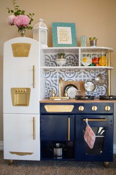 a blue and white toy stove top oven next to a shelf with pots and pans on it