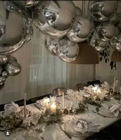 the table is set with silver and white decorations