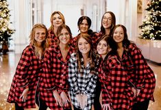 a group of women in red and black flannel pajamas posing for a photo