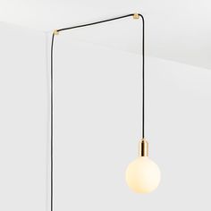 a light that is hanging from the ceiling in a room with white walls and flooring