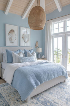 a bedroom with blue walls and white bedding, two pictures hanging above the bed