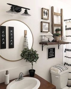 a bathroom with a toilet, sink and mirror on the wall next to a potted plant