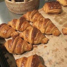 freshly baked croissants sit on a baking sheet in front of bread baskets