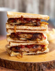 grilled sausage sandwich with onions and tomato sauce