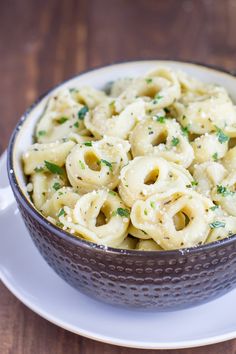 a bowl filled with pasta on top of a white plate