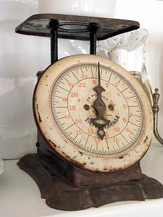 an old time clock sitting on top of a shelf next to other items in a kitchen