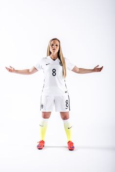 a female soccer player is posing for the camera with her arms outstretched in front of her