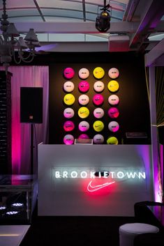 a neon sign that reads brookietown with lots of circles on the wall behind it