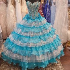 Blue Embellished Ball Gown With Fitted Bodice, Blue Ball Gown With Fitted Bodice For Pageant, Blue Ball Gown With Fitted Bodice For Pageants, Blue Princess Gown With Ruffles, Princess Style Blue Gown With Ruffles, Light Blue Ball Gown For Pageant, Blue Gown With Fitted Bodice For Quinceanera, Embellished Blue Dress For Quinceanera, Blue Ball Gown For Prom Season Pageant