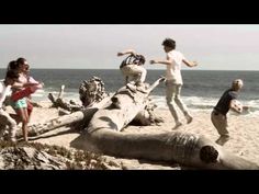 children playing on the beach with an elephant statue in front of them and another child standing next to it