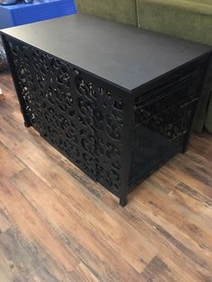 a black table sitting on top of a hard wood floor next to a green couch