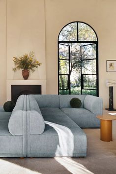 a living room with large windows and a blue couch