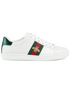 Step up your sneaker game with these stylish white leather ACE sneakers. Featuring a striking green and red web design and a luxurious gold thread embroidered bee detail on the side, these sneakers are a must-have for any fashion enthusiast. The lace-up closure, round toe, and unique red and green leather detail on the heel make these sneakers stand out from the crowd, while the rubber sole ensures maximum comfort and durability. Complete with the iconic embossed Gucci logo on the heel, these sn Red Web Design, Gucci Ace Sneakers, Embroidered Bee, Red Web, Bee Embroidery, Gucci Logo, Fashion Enthusiast, Leather Detail, Sneaker Games