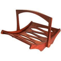 a wooden chair that is shaped like a slatted bench with curved arms and legs