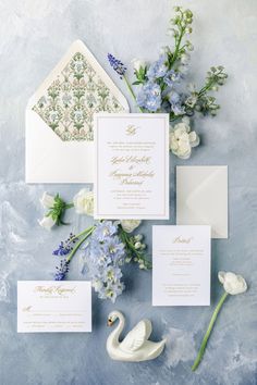 the wedding stationery is laid out with flowers and an envelope