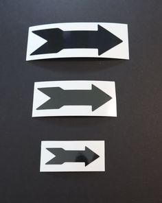 three black and white arrows pointing in opposite directions on a table with one arrow pointing right