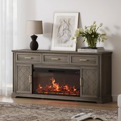 an entertainment center with a fire place in front of it and flowers on the table