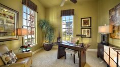 a living room filled with lots of furniture next to two windows and a ceiling fan