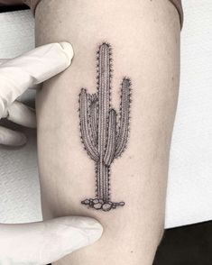 a small cactus tattoo on the right thigh